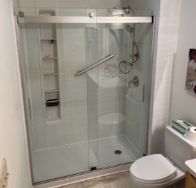 New shower with glass sliding doors, shelves, and an adjustable showerhead